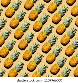 Pineapple pattern of whole pineapples. Flat lay diagonal with drop shadow on yellow-cream background.