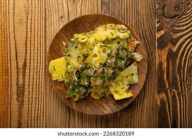 Pineapple Skin, Bio Garbage, Vegetable Waste, Pineapple Peel, Fruit Peeling Waste Pile, Organic Compost Ingredient on Wood Background Top View