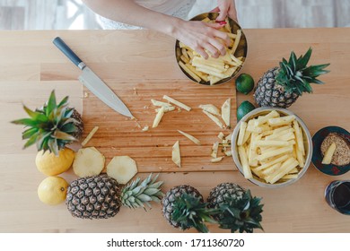 Pineapple Sliced By A Girl On The Kitchen Counter. Pineapples Contain A Group Of Digestive Enzymes As Bromelain, Function As Proteases, Break Down Protein Molecules Into Amino Acids And Small Peptides