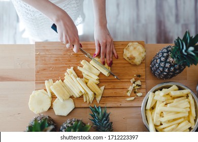 Pineapple Sliced By A Girl On The Kitchen Counter. Pineapples Contain A Group Of Digestive Enzymes As Bromelain, Function As Proteases, Break Down Protein Molecules Into Amino Acids And Small Peptides