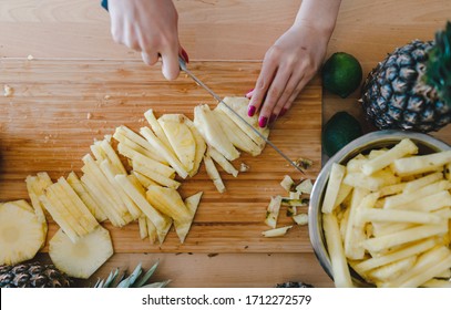 Pineapple Sliced By A Girl On The Kitchen Counter. Pineapples Contain A Group Of Digestive Enzymes As Bromelain, Function As Proteases, Break Down Protein Molecules Into Amino Acids And Small Peptides