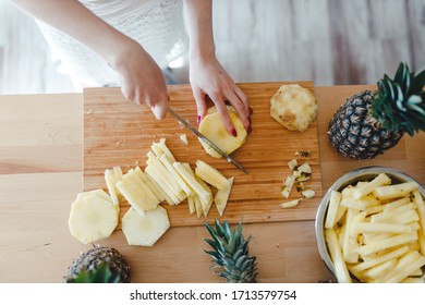 Pineapple Sliced By A Girl On The Kitchen Counter. Pineapples Contain A Group Of Digestive Enzymes As Bromelain, Function As Proteases, Break Down Protein Molecules Into Amino Acids And Small Peptides