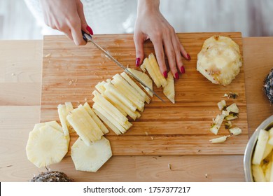 Pineapple Sliced By A Girl On The Kitchen Counter. Pineapples Contain A Group Of Digestive Enzymes As Bromelain, Function As Proteases, Break Down Protein Molecules Into Amino Acids And Small Peptides