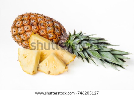 Pineapple and slices on the white table