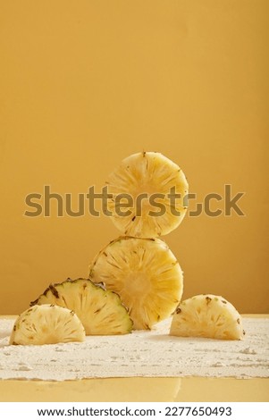 Pineapple slices are stacked and decorated on a light yellow background. Natural organic beauty cosmetics concept. Promote product extracted from pineapple (Ananas comosus)