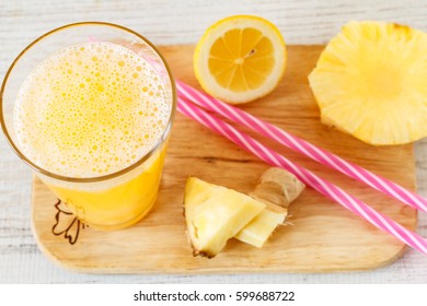 Pineapple,lemon  And Ginger  Juice In Glassware On Wooden Table. Top View.
