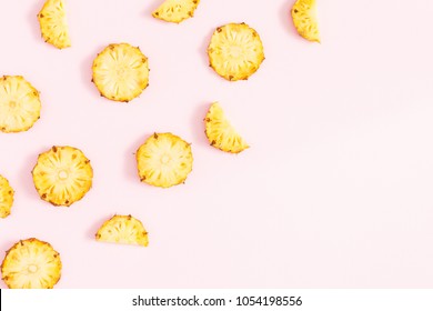 Pineapples on pink background. Pattern made of sliced pineapples. Flat lay, top view, copy space