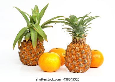 Pineapples and oranges on white background.