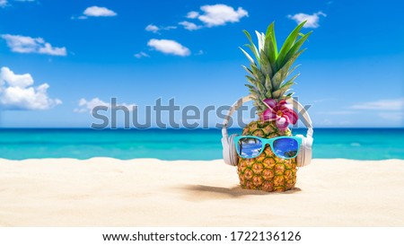 PinePineapple with sunglasses and headphones at tropical beach - Holiday Vacation Concept