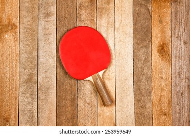 Ping Pong Paddle Against Wooden Background