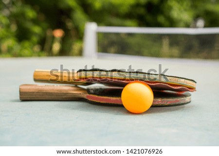 Ping pong paddles and ball on retro  blue wooden background. Rackets ruined by time