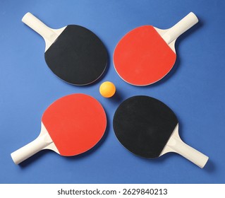Raquetas de ping pong y bola sobre fondo azul, juego plano