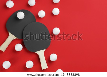 Ping pong rackets and balls on red background, flat lay. Space for text