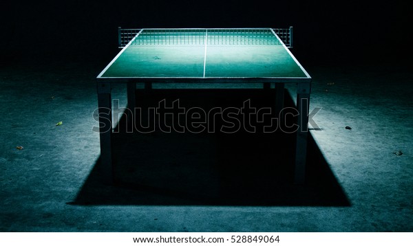 Ping pong table\
at night with strong\
shadows