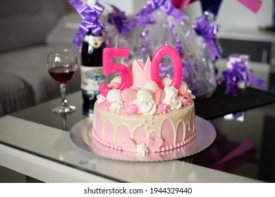 A Pink 50th Birthday Cake With A Crown And Can