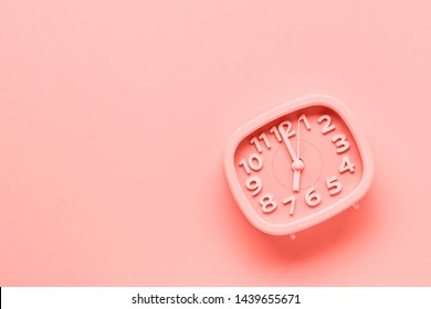Pink alarm clock lying on yellow surface background. TTrendy living coral color of year 2019.op view.  - Shutterstock ID 1439655671
