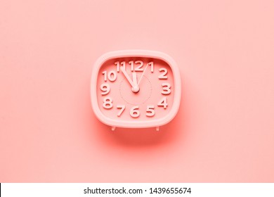 Pink alarm clock lying on yellow surface background. TTrendy living coral color of year 2019.op view.  - Shutterstock ID 1439655674