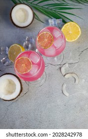 Pink Alcoholic Drink Cocktail With Lemon And Coconut And Palm Leaf