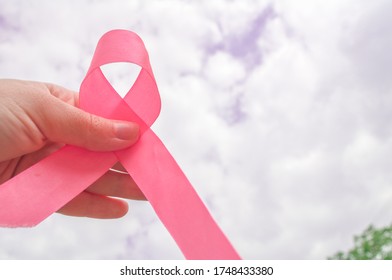 Pink awareness ribbon. Breast Cancer Ribbon. Hand with pink awareness ribbon. Support for women who survive breast cancer. Hand support. October Awareness Month. World Breast Cancer Day.  - Shutterstock ID 1748433380