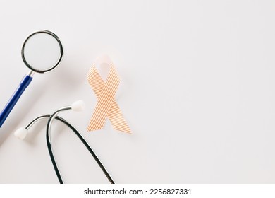 Pink awareness ribbon sign and stethoscope of International World Cancer Day campaign month isolated on white background with copy space, concept of medical and health care support, 4 February - Shutterstock ID 2256827331