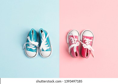 Pink Baby Girl And Blue Baby Boy Sneakers  On A Pink And Blue Background. Flat Lay, Top View.