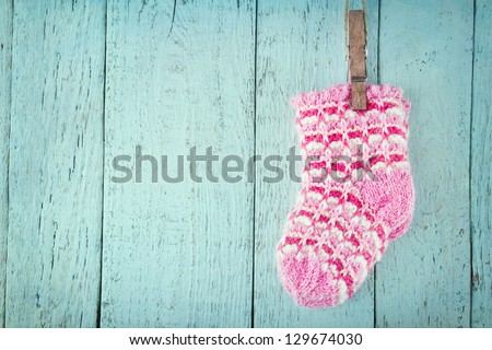 Pink baby socks on a blue wooden rustic background with copy space