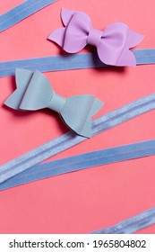 Pink background, with blue ribbon and pink and blue leather bows to decorate girls hair