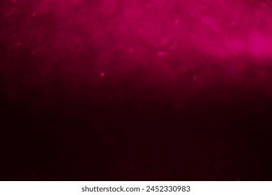 A pink background with a blurry pink object in the foreground. The background is dark and the object is blurry, giving the impression of movement and energy
