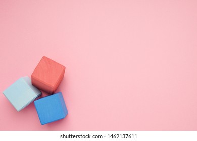 Pink background with colorful wooden cubes.Creativity toys. Children's building blocks.