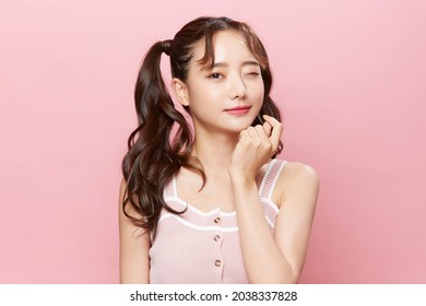 Pink background portrait of a young Asian woman with pigtails - Shutterstock ID 2038337828