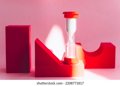 pink background with red geometric shapes and hourglass - Shutterstock ID 2208771817