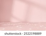 Pink background with a terrazzo pattern foreground. Table for product display with pink background and terrazzo pattern, shadows and natural sun light. Pink studio background with light shadow.