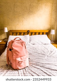Pink backpack on a bed. Vertical shot.