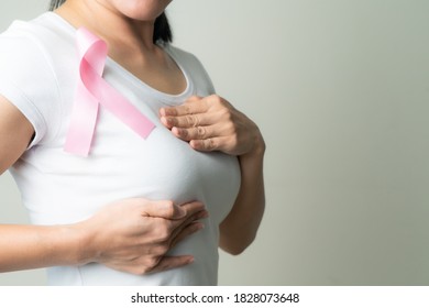 pink badge ribbon on woman chest to support breast cancer cause. breast cancer awareness concept - Shutterstock ID 1828073648