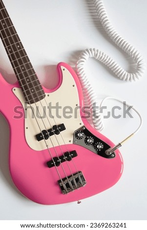 Pink bass guitar on white background