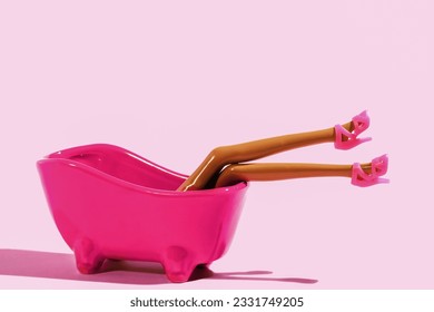 Pink bath with doll legs in pink shoes on pink background. 