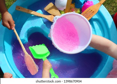 Pink Bath Jelly In A Water Table Activity.
Fun Summer Time Activity. Children Enjoying This Experimental Play/STEM Activity.