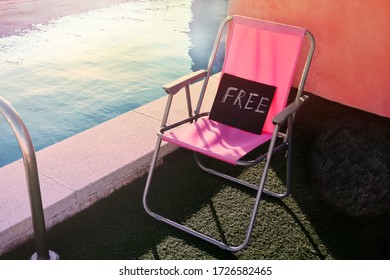 A Pink Beach Chair With A Black Poster With A Word Free Standing Next To The Swimming Pool On The Terrace On A Sunny Day 