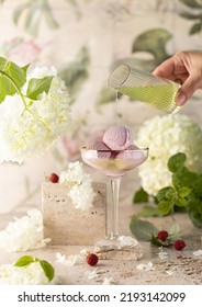 Pink Berries Ice Cream With Menthol Syrup In Crystal Glass With White Flowers On Stone Background.Healthy Vegan Dessert.