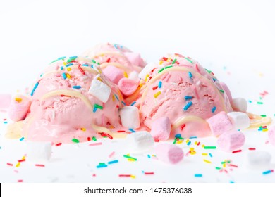 pink berry scoops ice cream strewed sprinkles, marshmallows and icing on white background