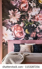 Pink And Black Pillows On Bed Against Flowers Wallpaper In Overwhelming Bedroom Interior. Real Photo