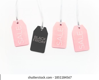 Pink and black tags on white background. Glamorous labels on silver threads. Black Friday sale and shopping. Top view, flat lay.