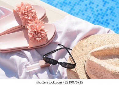 Pink Blanket With Beach Accessories Near Outdoor Swimming Pool On Sunny Day, Above View