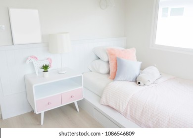 Pink Blanket And Pillows On Bed In Colorful Kids Room With Cute Doll And Side Table.