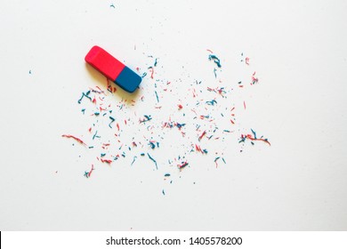Pink and blue eraser and it’s shavings sitting on a clean white sheet of paper with copy space – Small office supply for correcting errors – Concept image for erasing mistakes and editing - Shutterstock ID 1405578200