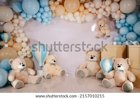 Pink and blue photo zone with balloons and teddy bears toys, one year birthday party rich decorated 