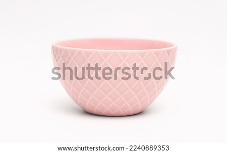 Pink bowl with checks on white background.
