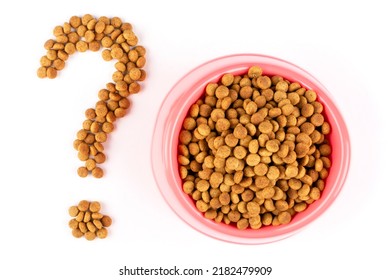 Pink Bowl With Dry Food For A Cat (dog) And A Question Mark On A White Isolated Background. Feed Quality, Diet, Norms. Balanced Nutrition Of Pets.