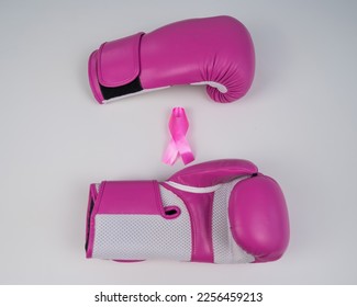 Pink boxing gloves and a pink silk ribbon on a white background. Breast cancer concept.  - Shutterstock ID 2256459213