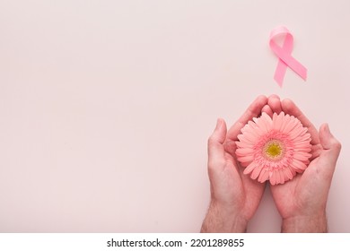 Pink Breast Cancer Awareness Ribbon. Hands holding gerbera and pink ribbon on backgrounds. Breast cancer awareness and October Pink day, world cancer day. Top view. Mock up. - Shutterstock ID 2201289855